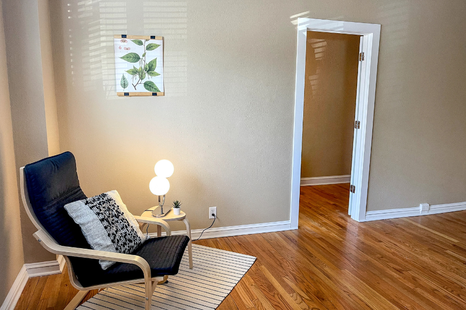 a small living room with a chair and a door to a closet