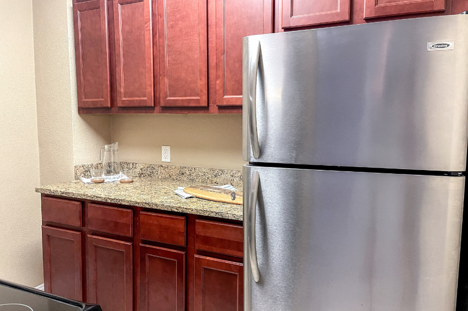 a kitchen with a stainless steel refrigerator and wooden cabinets