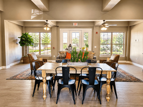 A dining room with a large table and chairs.