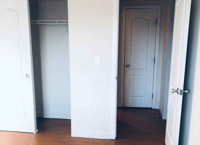 an empty room with a closet and a white door