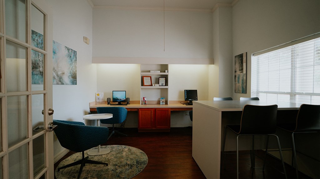 an office with a desk and chairs and a computer