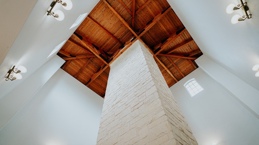 the ceiling of a living room with wooden beams and a column
