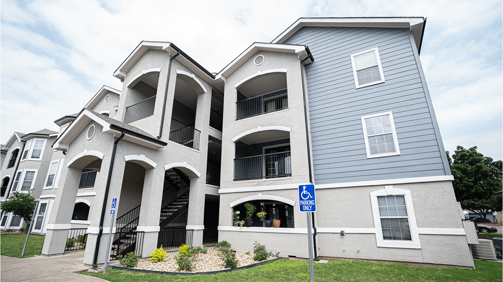 a grey and white building with a street sign in front of it