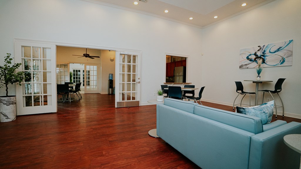 a living room with a blue couch and a hard wood floor