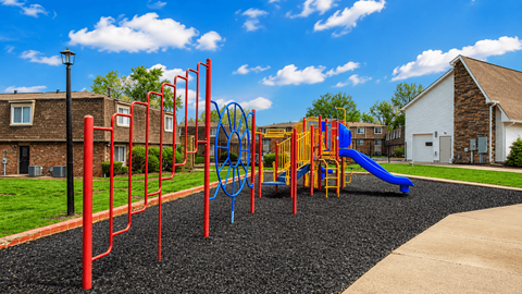 A playground with a blue slide and red monkey bars.