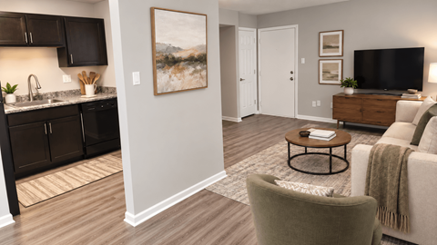 A living room with a grey couch and a painting on the wall.