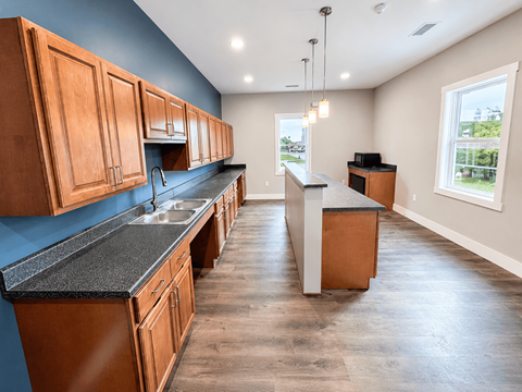 A kitchen with wooden cabinets and a black countertop.