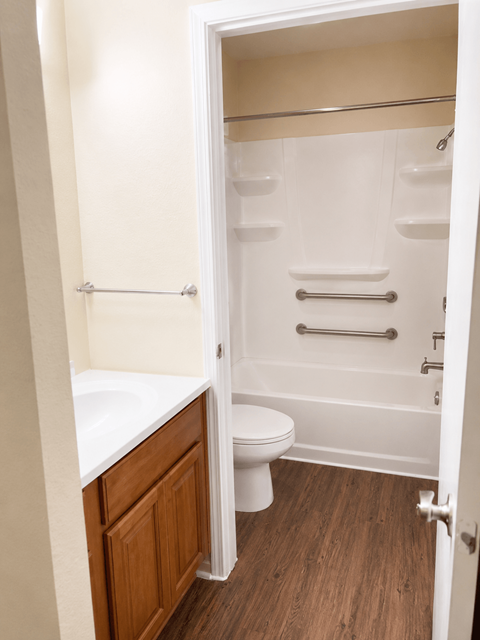 A white toilet is in a small bathroom with a walk-in shower.
