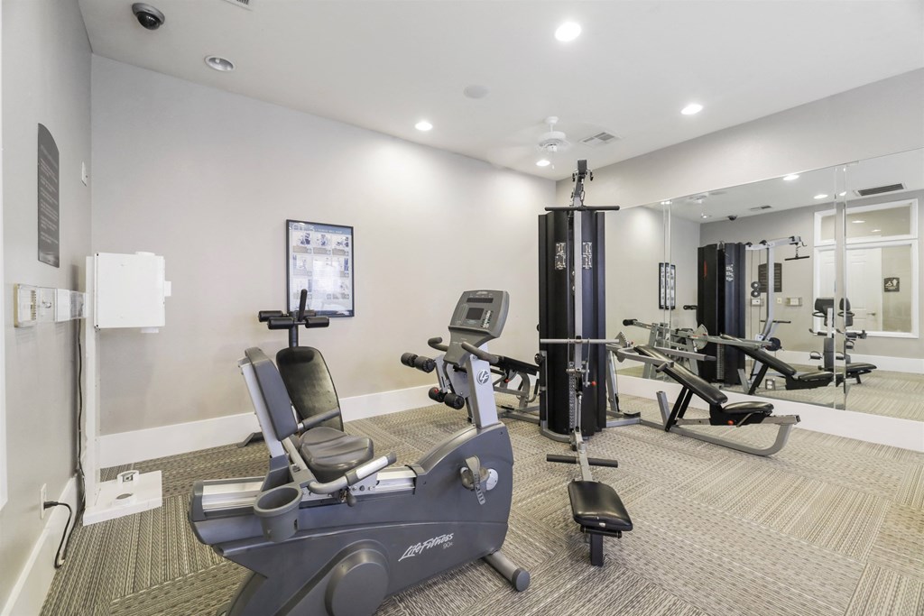 A gym with a rowing machine in the foreground.