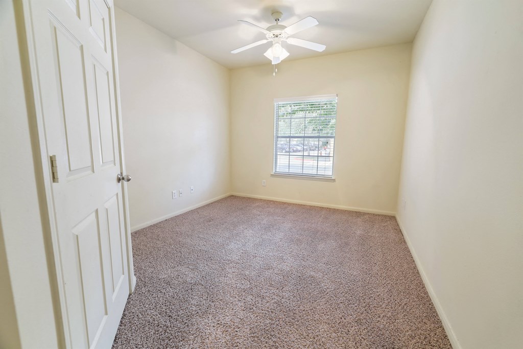 A room with a carpeted floor and a window.