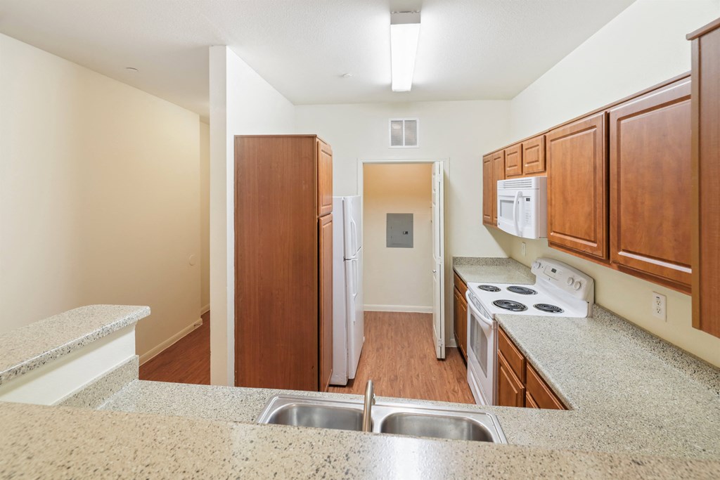 A kitchen with a sink, stove, and refrigerator.