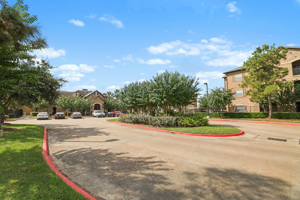 A sunny day at a residential area with houses and cars.