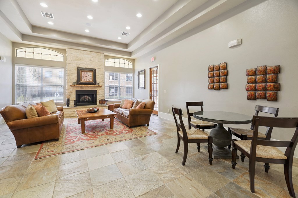 A living room with a fireplace and a dining table.