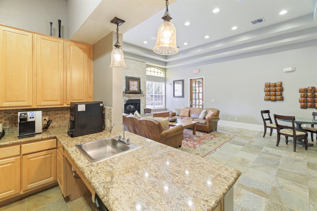 A kitchen with granite countertops and wooden cabinets.