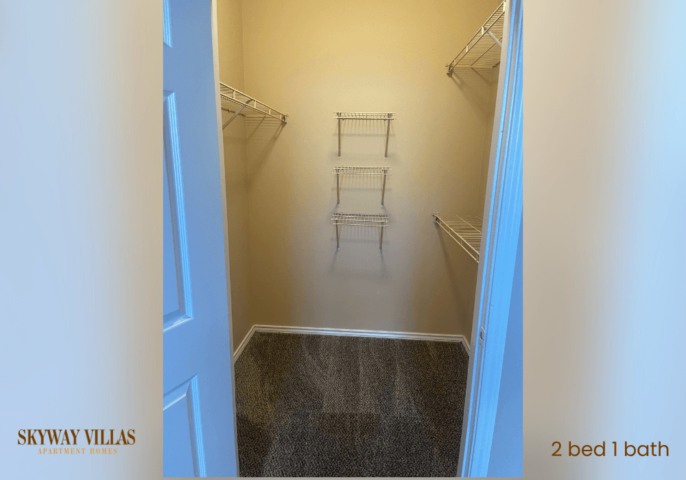 a walk in closet with 2 beds and two shelves