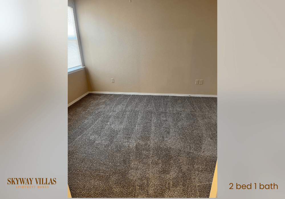 an empty room with a carpeted floor and a window