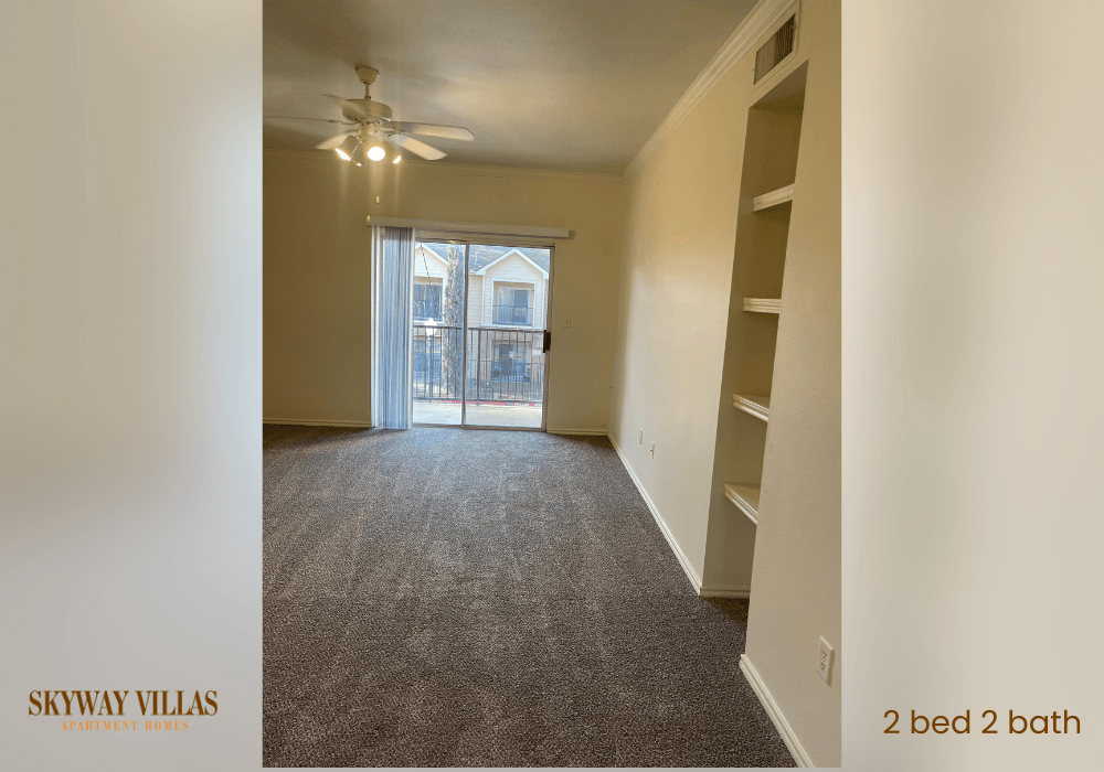 an empty living room with a closet and a ceiling fan