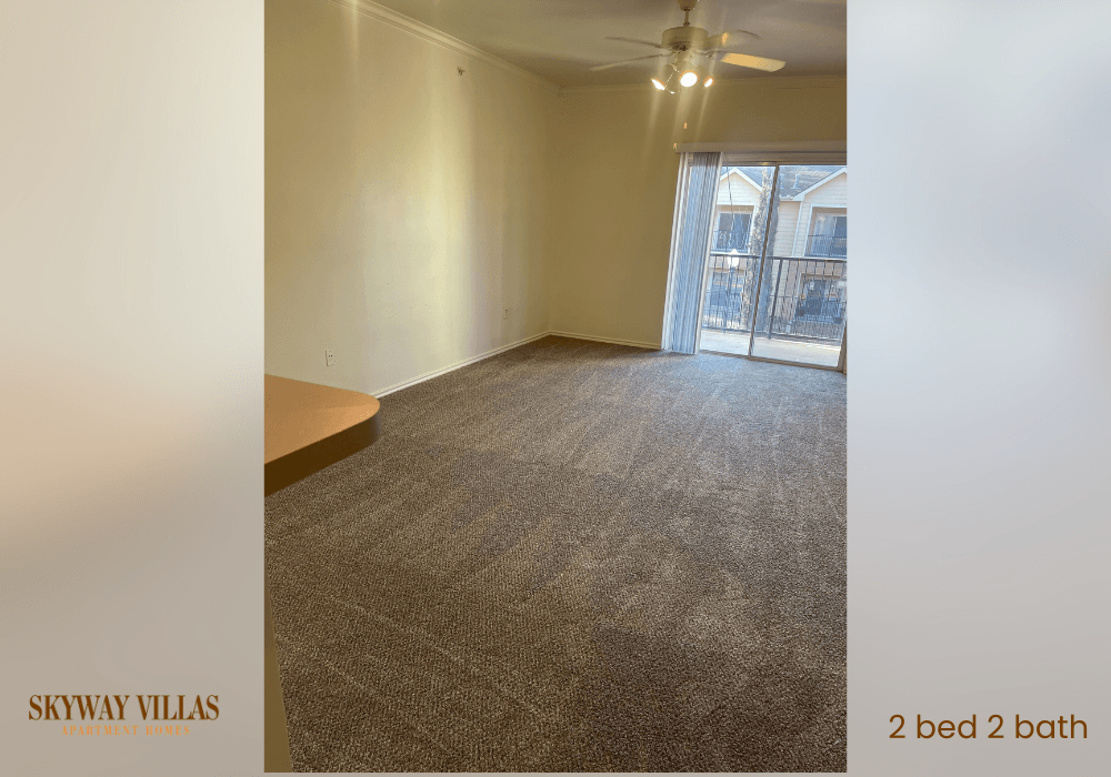an empty living room with carpet and a sliding glass door