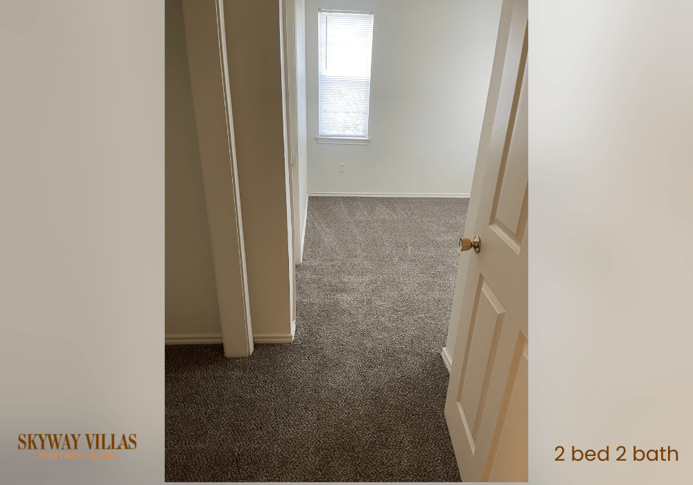 a room with a carpeted floor and a door and a window