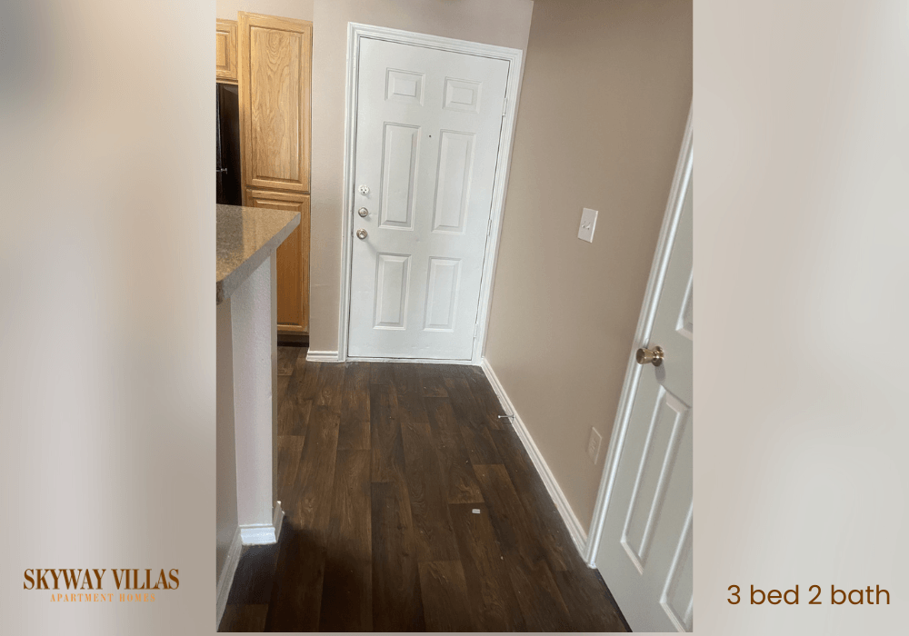 a room with a white door and a hallway with wood floors