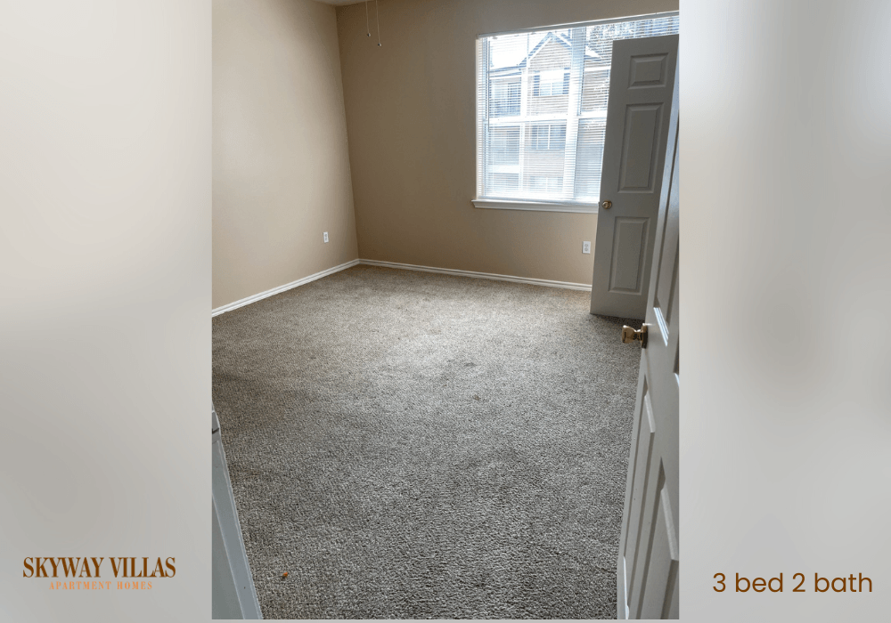 an empty bedroom with a carpeted floor and a window