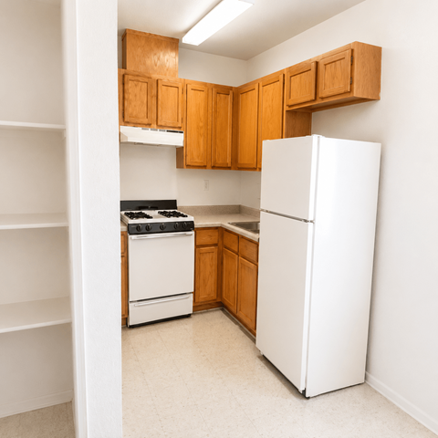 A kitchen with white appliances and wooden cabinets.