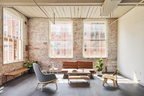 A living room with a brick wall and wooden furniture.