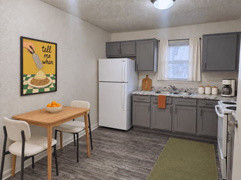 A kitchen with a white refrigerator, a table with chairs, and a painting on the wall.