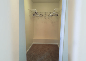 a closet with hooks and a carpet in a room