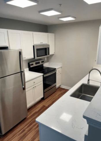 a kitchen with stainless steel appliances and white cabinets