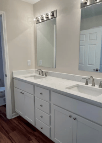 a white bathroom with two sinks and a mirror