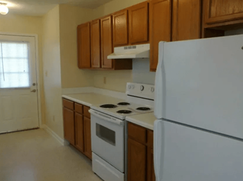 a kitchen with white appliances and wooden cabinets