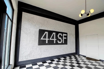 a mosaic on the wall in a room with a checkered floor