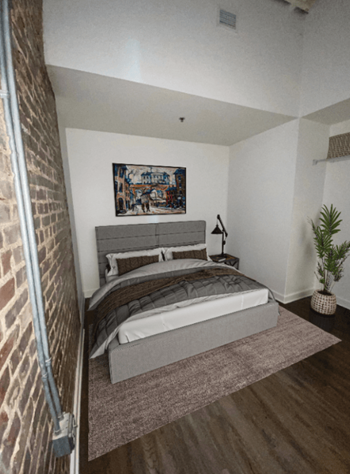 a bedroom with a bed and a brick wall at Lofts at Union Alley, Memphis