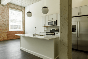 a white kitchen with a sink and a refrigerator at The Mill at Prattville, Prattville, AL