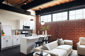 an open kitchen and living room with a brick wall at The Mill at Prattville, Prattville, 36067