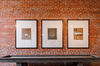 three pictures hanging on a brick wall at The Mill at Prattville, Prattville, 36067