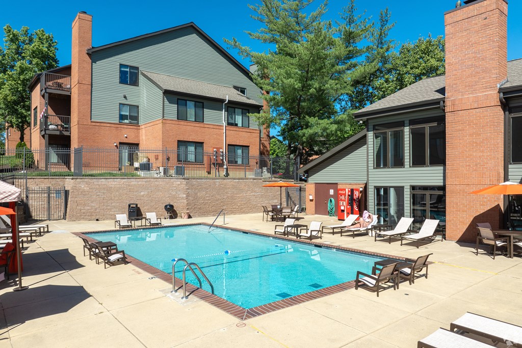A swimming pool surrounded by lounge chairs and umbrellas.