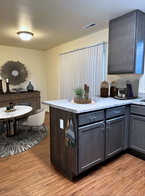 A kitchen with dark wood cabinets and a white countertop.