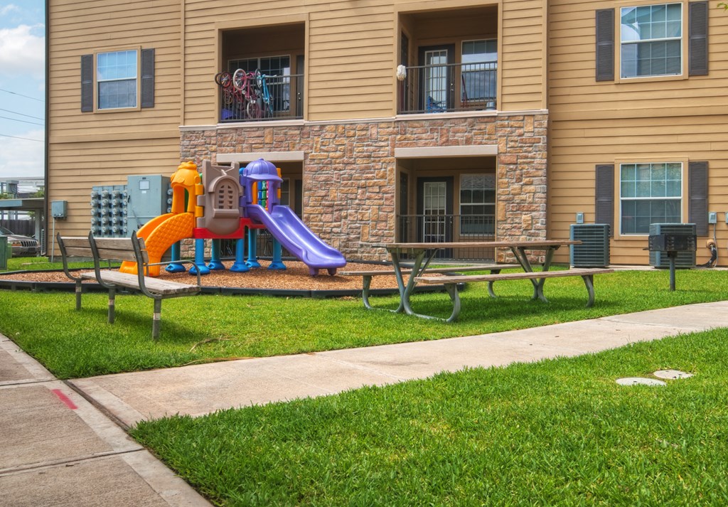 A playground with a slide and a purple slide.