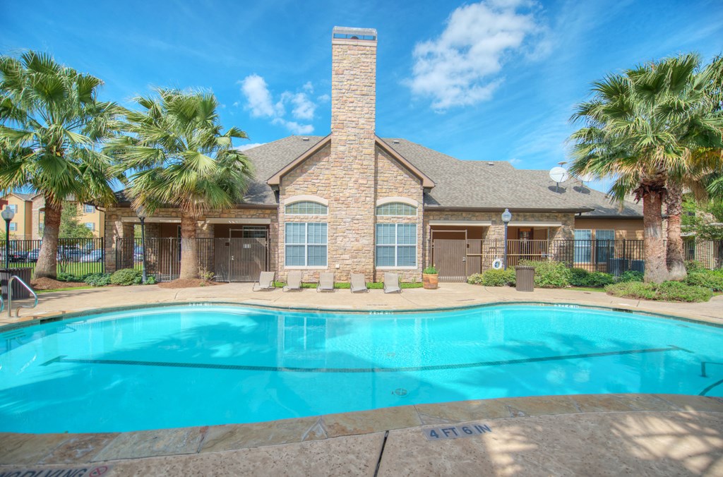 A house with a pool in front of it.