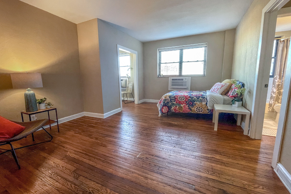 a bedroom with hard wood floors and a bed