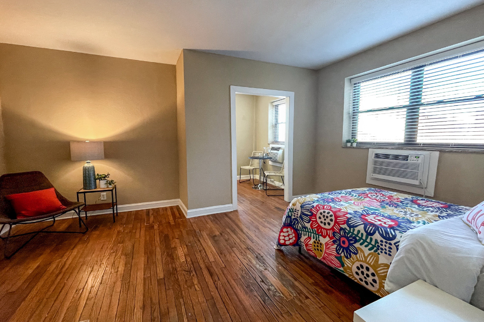 a bedroom with a bed and an air conditioner    and a window