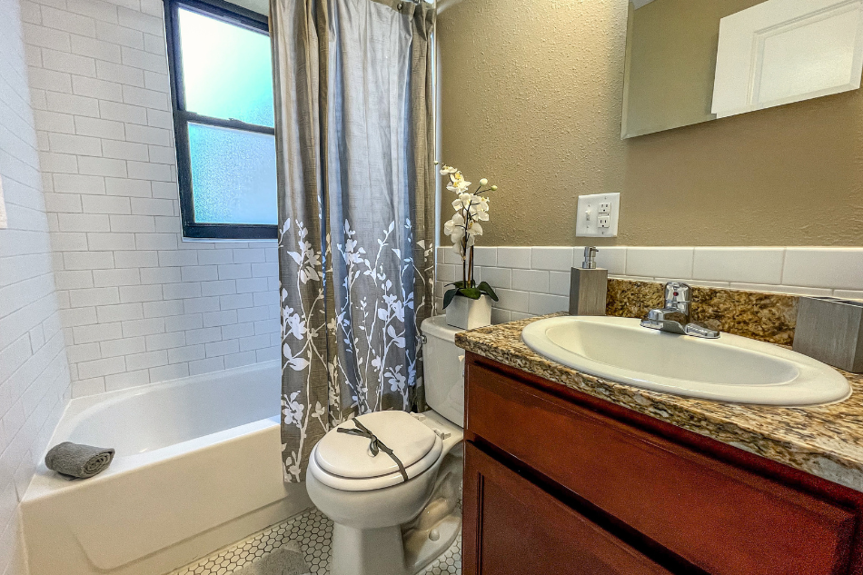 a bathroom with a sink toilet and tub and a shower curtain
