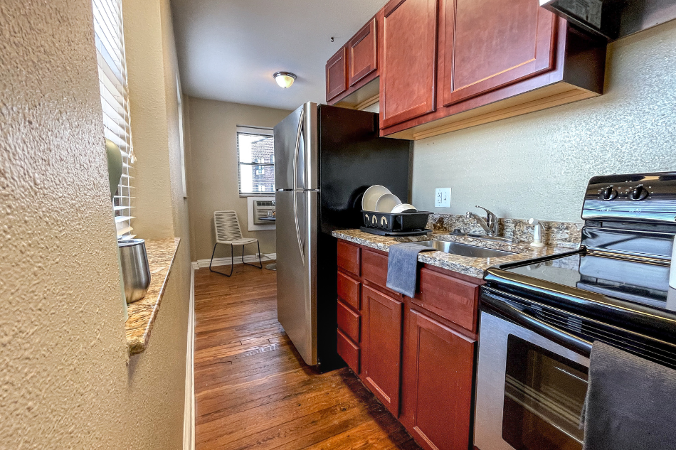 a kitchen with a stove and refrigerator and a sink