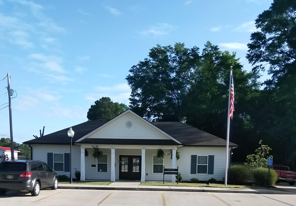 a white building with an flag and a car parked outside