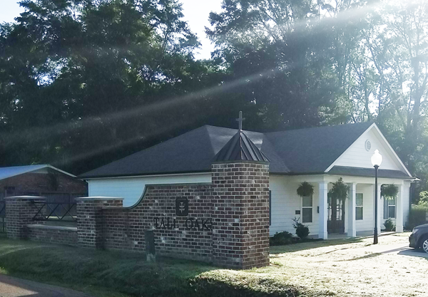 a church with a brick wall in front of a house