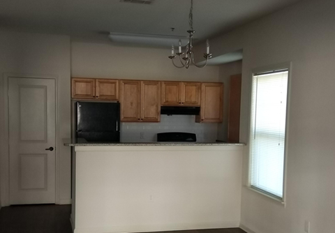 an empty kitchen with wooden cabinets and a white counter top