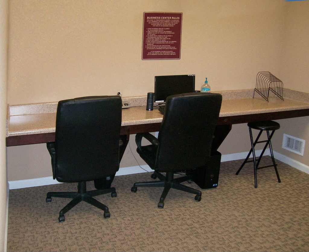 a desk with two chairs and a computer on it