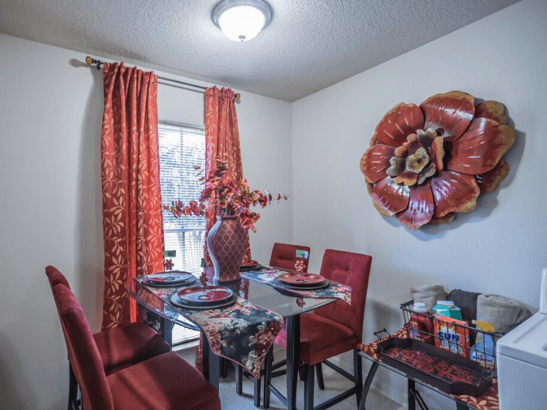 a dining room with a table and chairs and a large flower on the wall